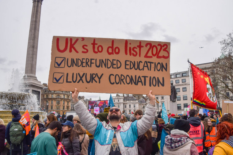 A protester holds a placard which states 'The UK's to-do list