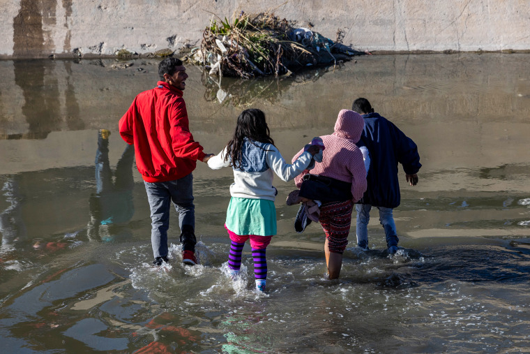 Migrants cross the Rio Grande into El Paso, Texas, on Jan. 8, 2023, from Ciudad Juarez, Mexico.