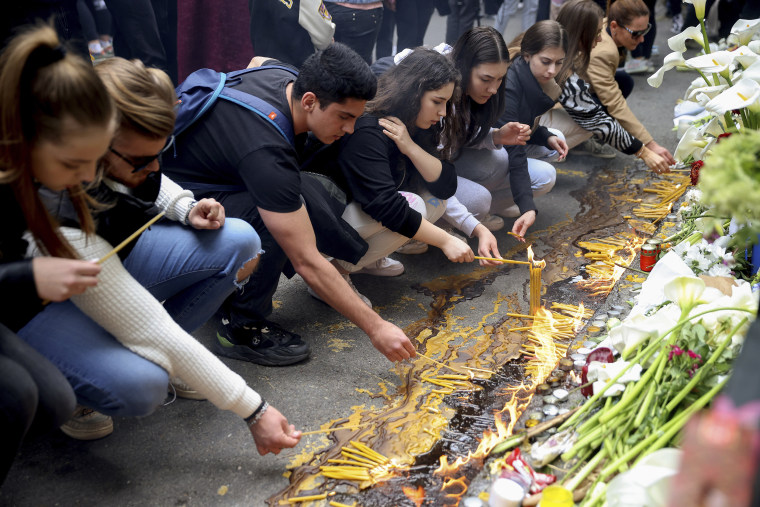 School children light candles near the Vladislav Ribnikar school in Belgrade, Serbia, Thursday, May 4, 2023. Many wearing black and carrying flowers, scores of Serbian students on Thursday paid silent homage to their peers killed a day earlier when a 13-year-old boy used his father’s guns in a school shooting rampage that sent shock waves through the nation and triggered moves to boost gun control.