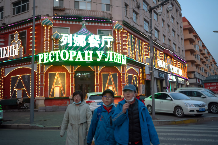 People cross the road outside a mall emblazoned with Russian and Chinese inscriptions in the city of Heihe in northern China last month.