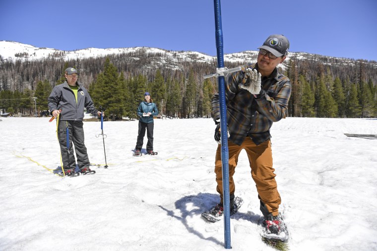 Sean de Guzman of the California Department of Water Resources inserts a snow depth measurement pole into snow in El Dorado County, California on May 1, 2023.