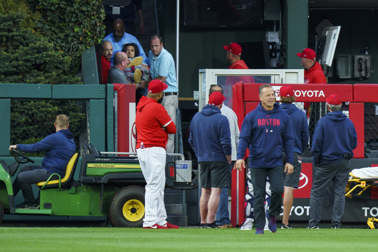 Medical staff carry a fan who fell into the Boston Red Sox bullpen during a game in Philadelphia