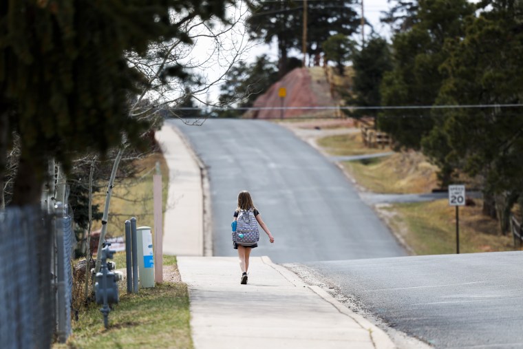 A girl walks home from Gateway Elementary School on April 12, 2023 in Woodland Park, Colo.