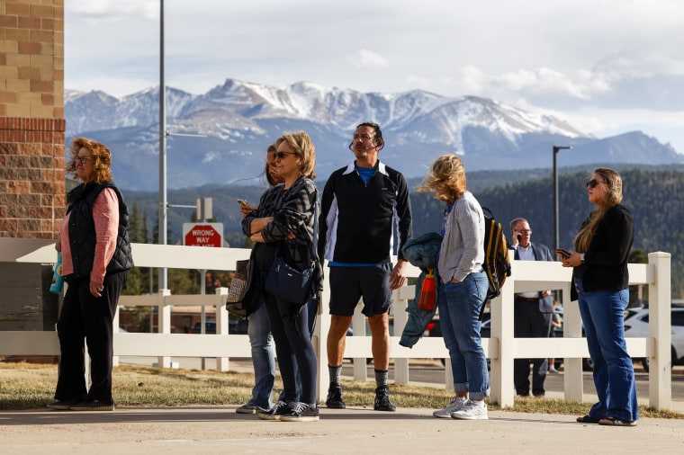 People wait outside of the Woodland Park School District Administration building to attend a school board meeting on April 12, 2023 in Woodland Park, Colo. 