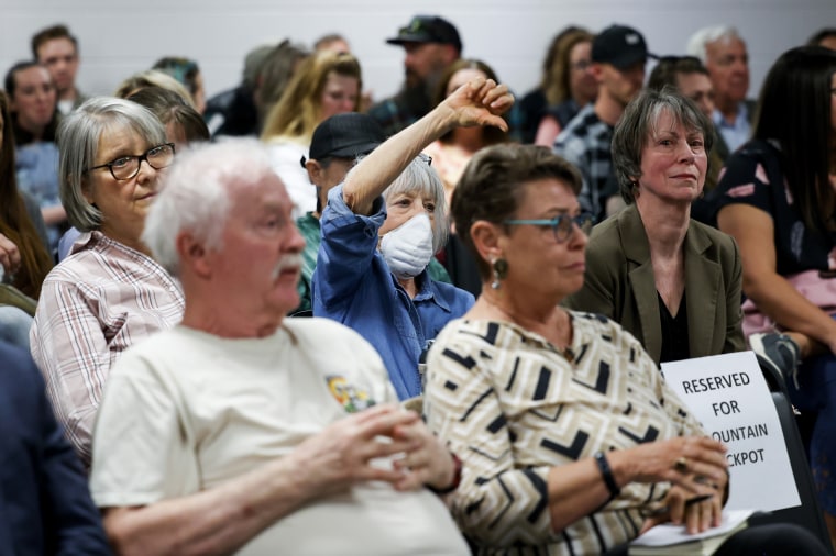 Woodland Park resident Gail Gerig, center, makes a thumbs down gesture during the public comment period of the Woodland Park School District Board of Education meeting on April 12, 2023 in Woodland Park, Colo.
