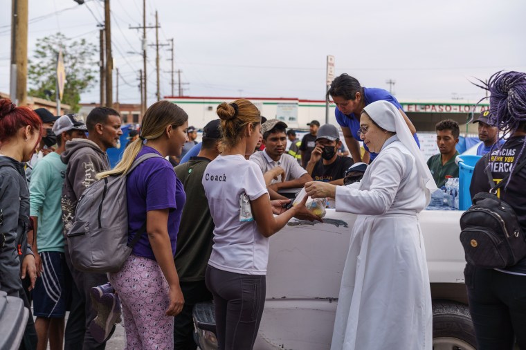 Migrantes hacen fila para recibir donaciones frente a la Iglesia del Sagrado Corazón antes del levantamiento del Título 42 en El Paso, Texas, el 3 de mayo de 2023.