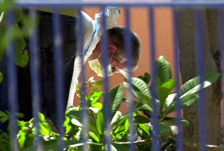 A Dutch investigator searches for clues outside the home of Joran van der Sloot in Aruba on June 15, 2005. 