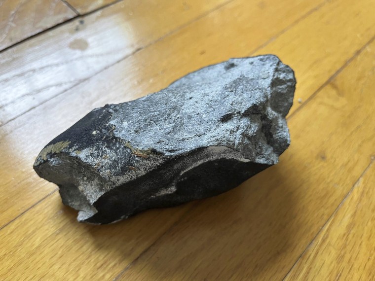 A meteorite rests on a hardwood floor after crashing into at a residence in Hopewell Township, N.J.