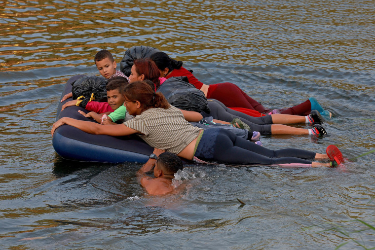 Migrants make their way across the Rio Grande on May 11, 2023 in Matamoros, Mexico. 