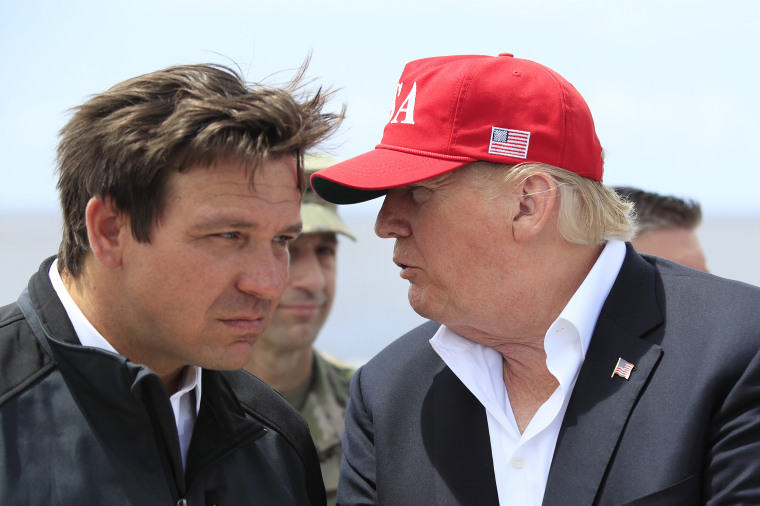 Then-President Donald Trump speaks to Gov. Ron DeSantis in Canal Point, Fla