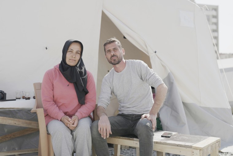 Sevsem Baran and Ferdi Baran in sit in their tent in a tent city in Hatay, Turkey.