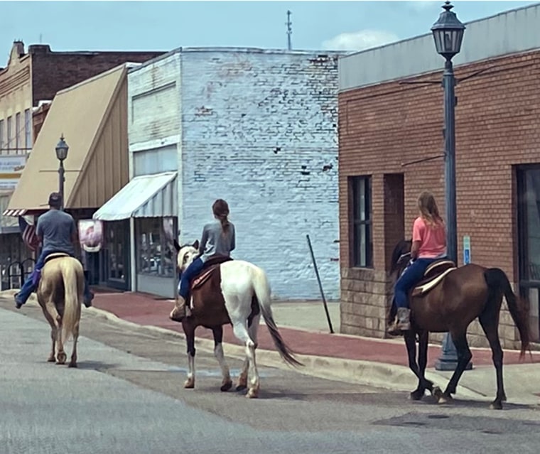 Image: Barry Walker, left, rides horses through Glenwood, Ark. with young girls.