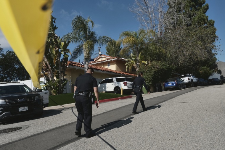 Police officers block the street access to a house in Beverly Crest, where three people were killed and four others wounded  Jan. 28, 2023. 