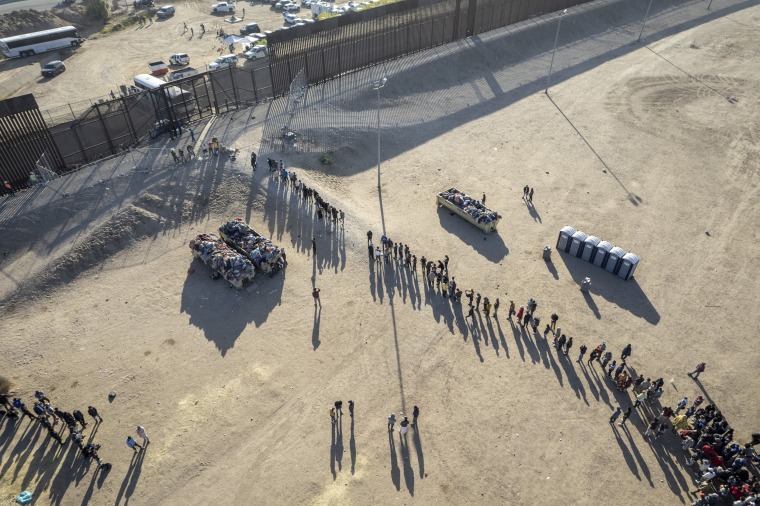Migrants wait be processed by U.S. Border Patrol agents in El Paso, Texas