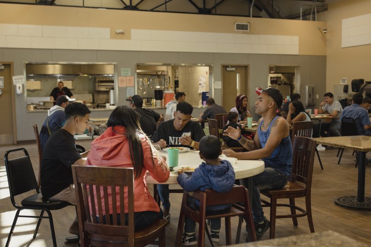 Migrants from Venezuela eat in the dinning hall at the Rescue Mission of El Paso in El Paso, Texas