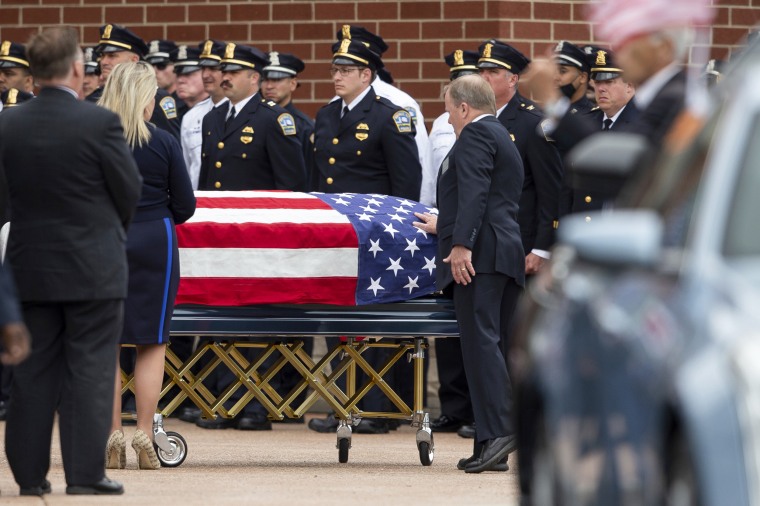 A person touches the casket of Aaron Salter Jr. during a funeral service in Getzville, N.Y., on May 25, 2022.