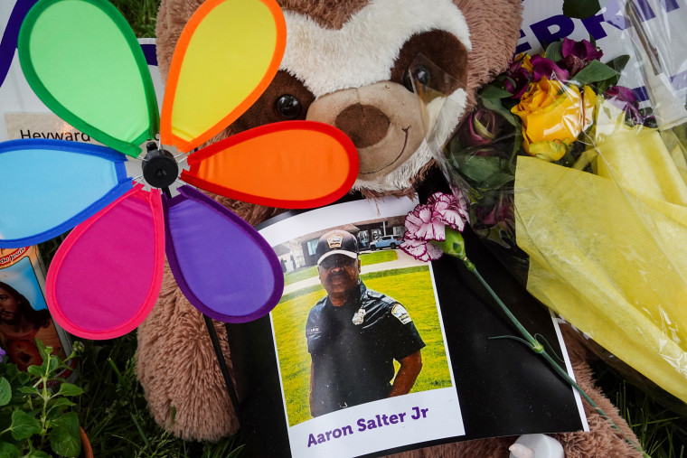 Flowers, candles and mementoes are left in honor Aaron Salter Jr., the hero security guard who was shot and killed trying to stop a gunman at the Tops supermarket, in Buffalo, N.Y., on May 18, 2022.