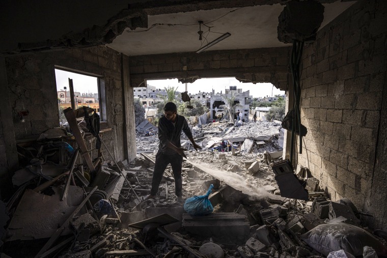 Palestinians inspect the rubble at the site of an airstrike that the Israeli military said targeted the house of an Islamic Jihad member, in Deir al-Balah, central Gaza Strip, on May 13, 2023.