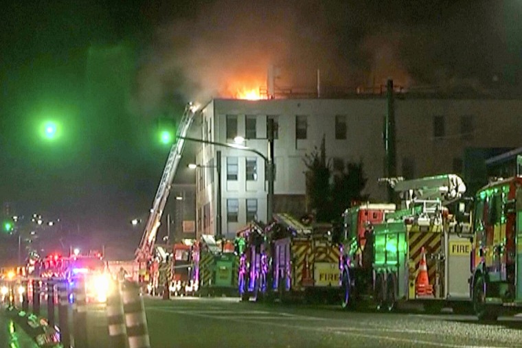 In this image made from video, firetrucks stage outside a hostel in central Wellington, New Zealand, early Tuesday, May 16, 2023. Several people were killed after a fire broke out overnight at the four-story building.