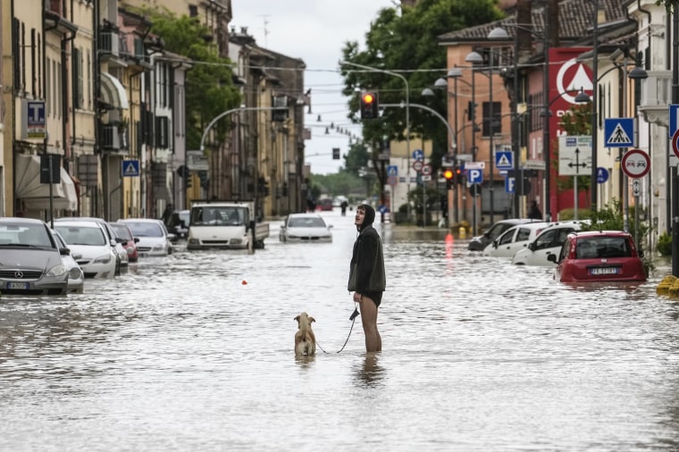 Imagen: Un hombre pasea a su perro por una calle inundada en Castel Bolognese, Italia, el 17 de mayo de 2023. 