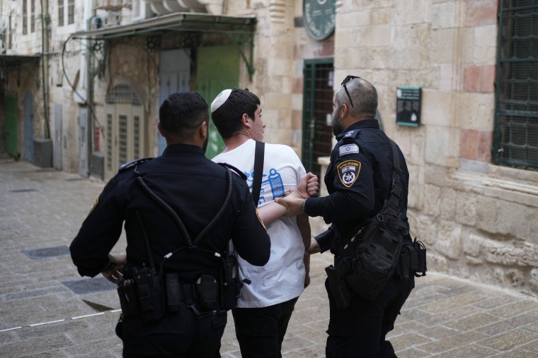 Israeli police officers detain an Israeli youth after his group was chanting slogans at the entrance to the Al Aqsa Mosque compound during a march in Jerusalem's Old City on May 18, 2023.