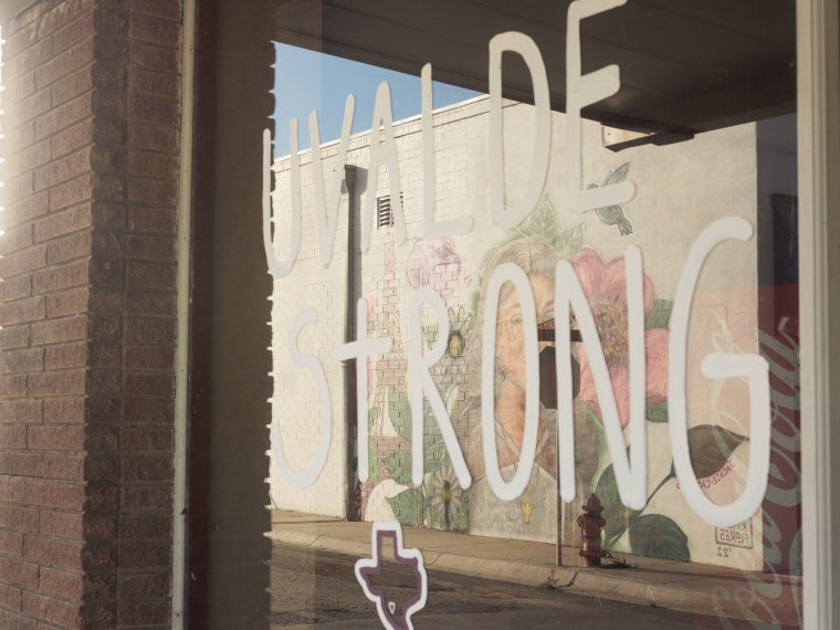 A mural of Jackie Cazares is reflected in a window inscribed with the phrase “Uvalde Strong,” on April 25, 2023 in Uvalde, Texas.