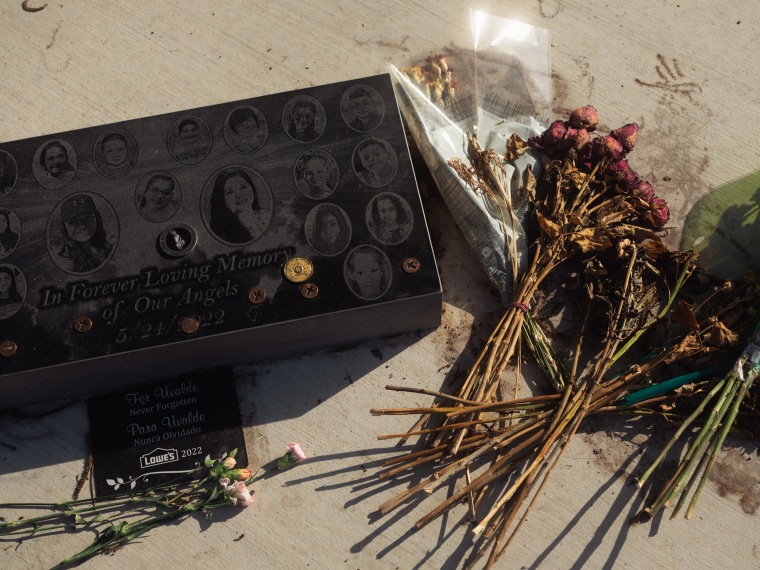 Flowers sit on the ground around a memorial to those who died in the massacre at Robb Elementary School on April 25, 2023 in Uvalde, Texas.