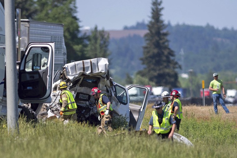 Oregon State Police troopers and firefighters work near the site of a wrecked tractor-trailer on May 18, 2023, along Interstate 5 in Albany, Ore. 