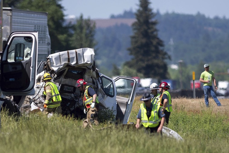 Oregon State Police soldiers and firefighters work near the site of a crashed tractor-trailer