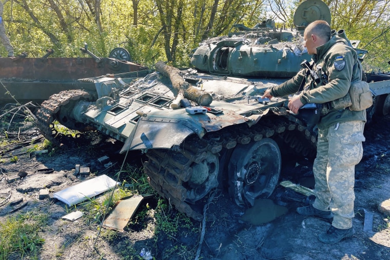 A Russian tank is examined for remains.