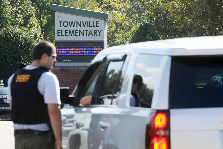 Members of law enforcement talk in front of Townville Elementary School on Wednesday, Sept. 28, 2016, in Townville, S.C.   A teenager opened fire at the South Carolina elementary school Wednesday, wounding two students and a teacher before the suspect was taken into custody, authorities said.  (AP Photo/Rainier Ehrhardt)