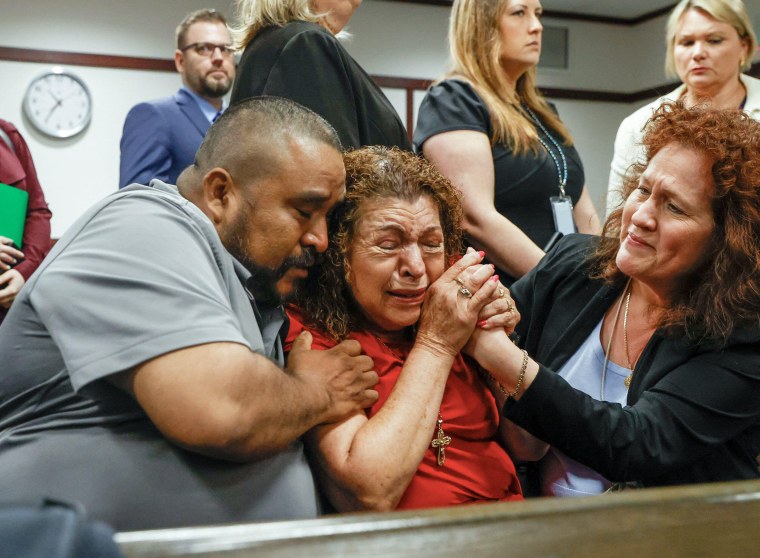 Tampa, Florida, USA. 28th Mar, 2023. Alejandro Corona Garcia, left, and Paz Quezada, center, who is the mother of Juan and Sergio Guitron, and victim advocate Stella Carabine, right, share a moment after a guilty verdict is read in the retrial of Michael