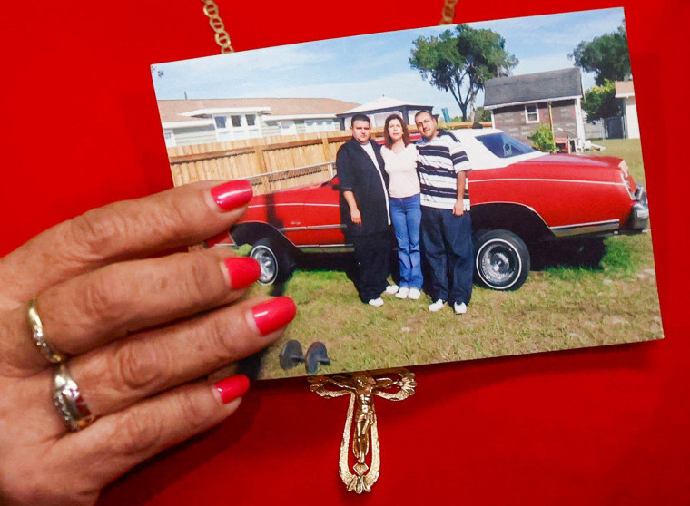 Paz Quezada holds a photo of her with her sons, Juan and Sergio Guitron.