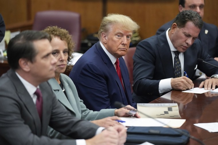 Former President Donald Trump sits at the defense table with his legal team in court