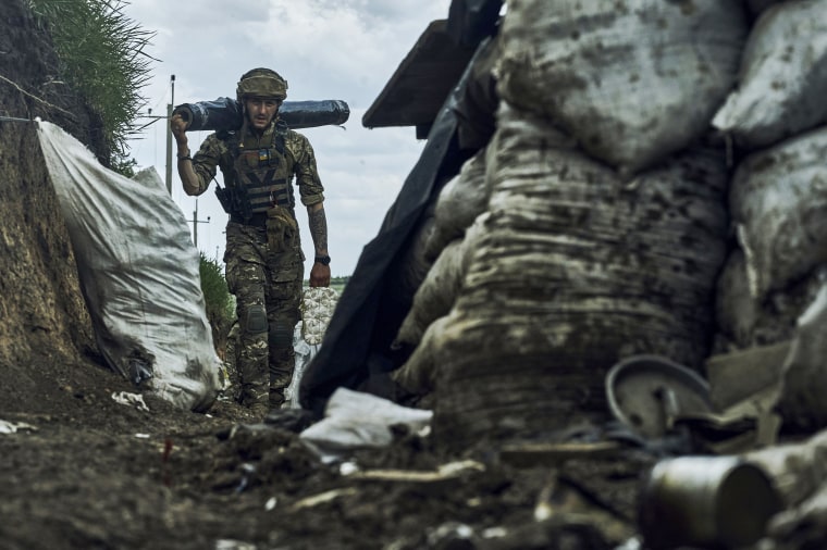A Ukrainian soldier carries supplies in a trench at the frontline near Bakhmut on May 22, 2023.