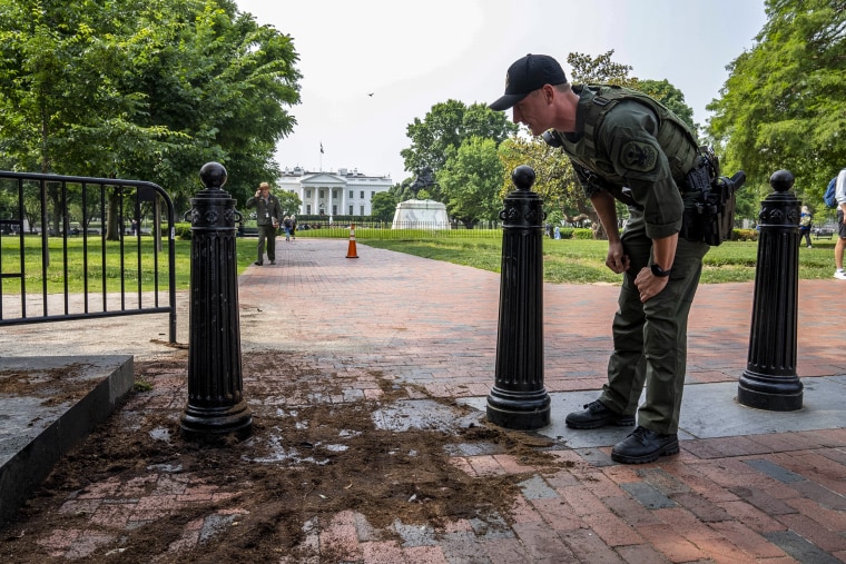 Image: A U.S. Park Police officer inspects a security barrier for damage in Lafayette Square park near the White House on May 23, 2023.
