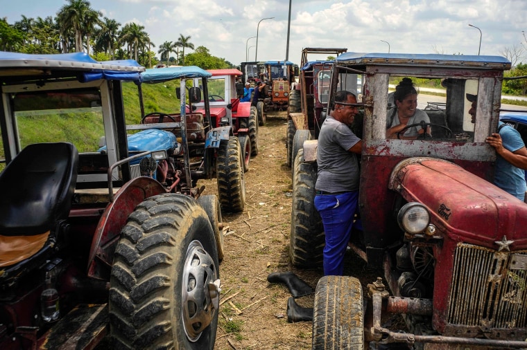 Farm workers wait in line to refuel their tractors on the highway to Pinar del Rio, Guanajay, Cuba, on May 18, 2023. 