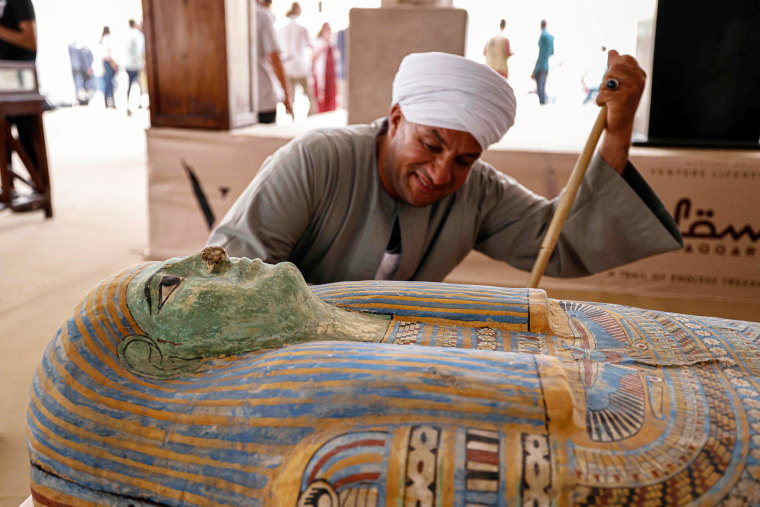 Mostafa Abdo Sadek observes a newly discovered sarcophagus in the Saqqara necropolis in Egypt,
