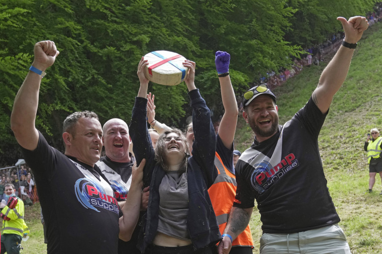 Delaney Irving holds the cheese after winning the women's downhill race in Gloucestershire, southwest England, on May 29, 2023.