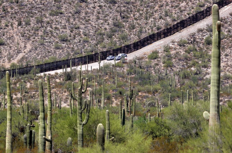 FILE - U.S. Customs and Patrol Patrol agents sit along a section of the international border wall that runs through Organ Pipe Cactus National Monument, Thursday, Aug. 22, 2019 in Lukeville, Ariz. U.S. Border Patrol agents answering reports of gunfire shot and killed a man on a tribal reservation in southern Arizona after he abruptly threw something and raised his arm, the agency said Monday, May 22, 2023.