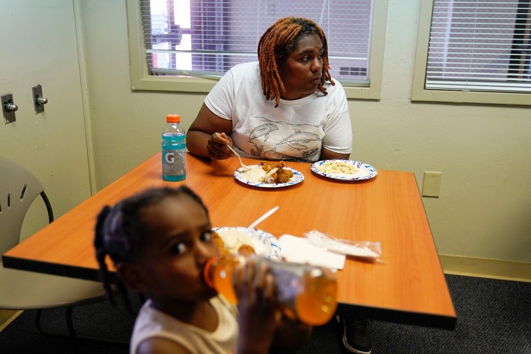 A tenant who escaped from the sixth floor after her apartment building that partially collapsed Sunday afternoon eats lunch inside a Red Cross shelter in Davenport, Iowa, on May 31, 2023.