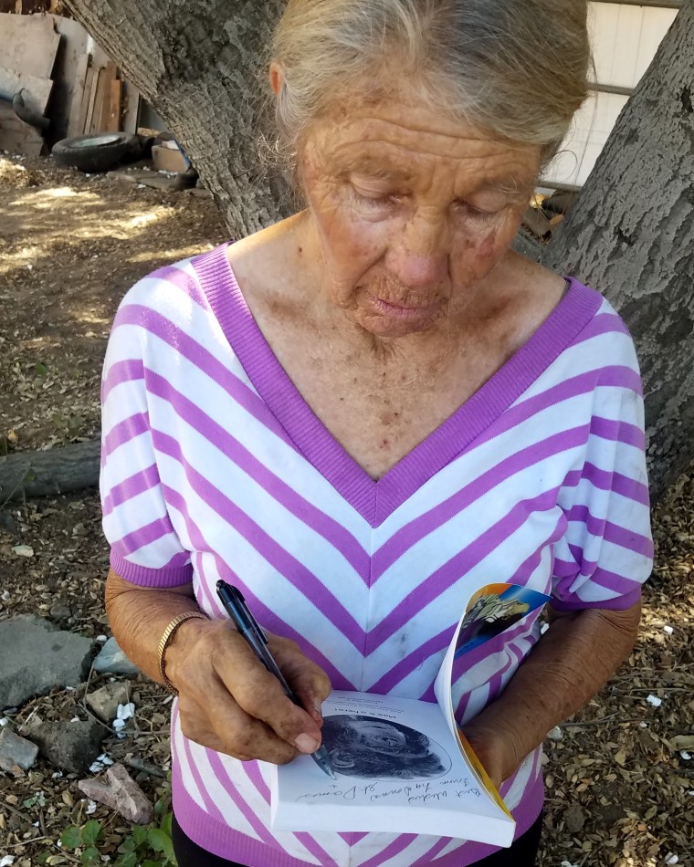 Image: LaDonna Davis signs a book about Moe the Chimp 