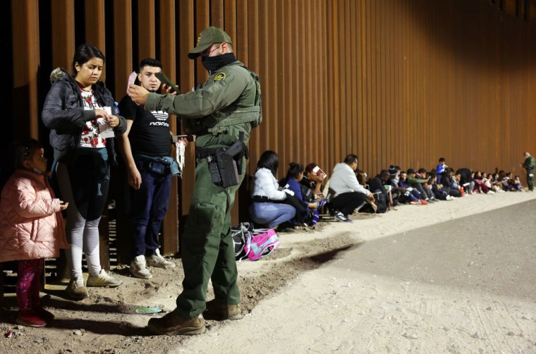 Un agente estadounidense comprueba los datos de un grupo de migrantes, a la espera de ser procesados en Yuma, Arizona, el 11 de mayo de 2023 tras el vencimiento del Título 42.