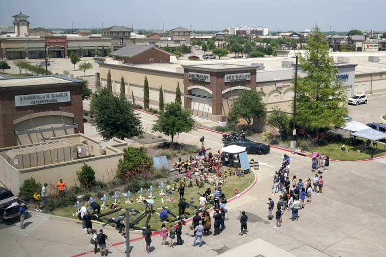 Un grupo de personas se reúne cerca del lugar de la masacre en el centro comercial de Allen, Texas, el lunes 8 de mayo de  2023.