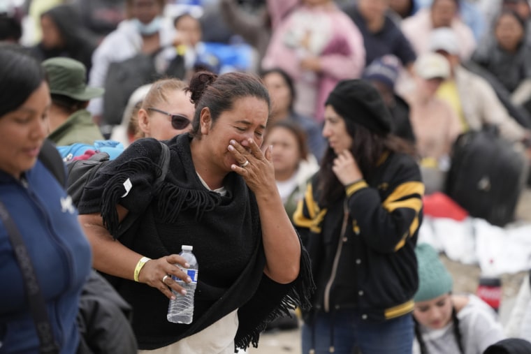 Una mujer llora el 12 de mayo de 2023, después de ser escogida por un agente de la Patrulla Fronteriza para ser procesada por funcionarios de inmigración, después de esperar dos días en la frontera.
