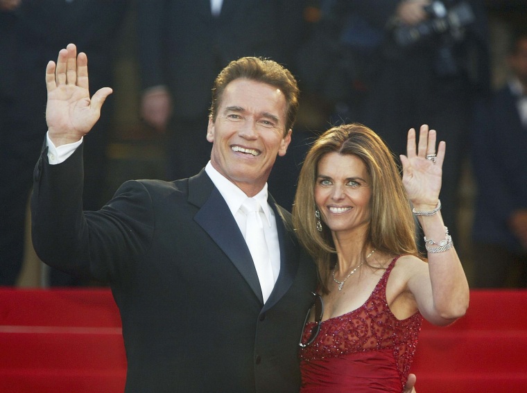 Arnold Schwarzenegger et son ex-femme Maria Shriver saluent les fans alors que le couple arrive pour la projection du film "Les Égares" au Palais des Festivals lors du 56e Festival international du film de Cannes le 16 mai 2003 à Cannes, France. 