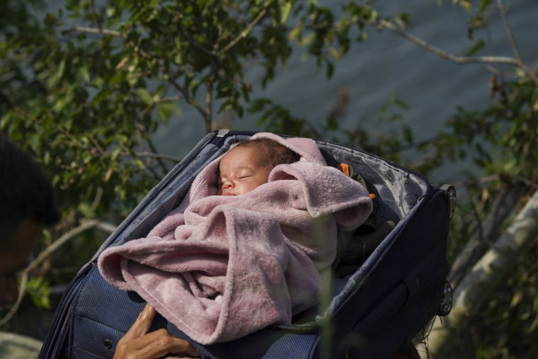 Un bebé de meses de vida es introducido en una maleta para cruzar el Río Grande, el 10 de mayo de 2023.