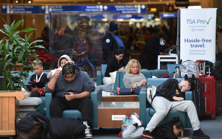 Viajeros esperan por sus vuelos en el Aeropuerto Internacional de Orlando durante la ajetreada temporada navideña de 2022. 