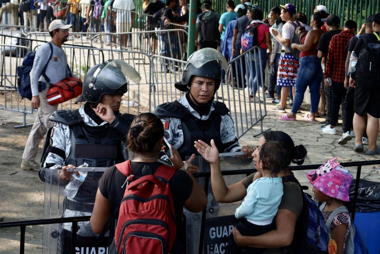 Oficiales de la Guardia Nacional Mexicana hablan con migrantes en un puesto de control migratorio en la frontera sur de México el 9 de mayo de 2023 en Tapachula, México.