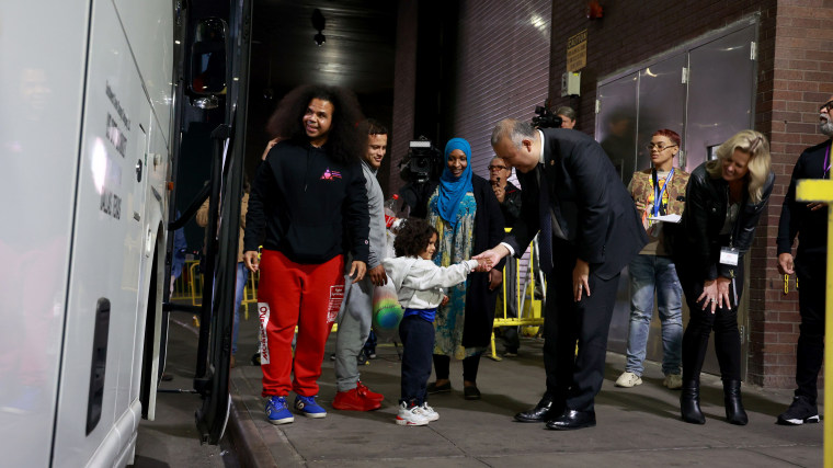 El comisionado de la Oficina de Asuntos de Inmigrantes del alcalde de la ciudad de Nueva York, Manuel Castro (centro), da la bienvenida a los inmigrantes que llegan a la Terminal de Autobuses de la Autoridad Portuaria en el centro de Manhattan.